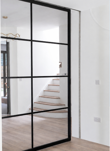 Metal framed glazed door with black framing and clear glass panels installed in a modern interior.