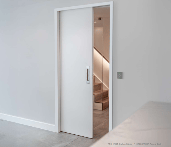 Modern interior featuring a powered pocket door system with an automatic sliding door.