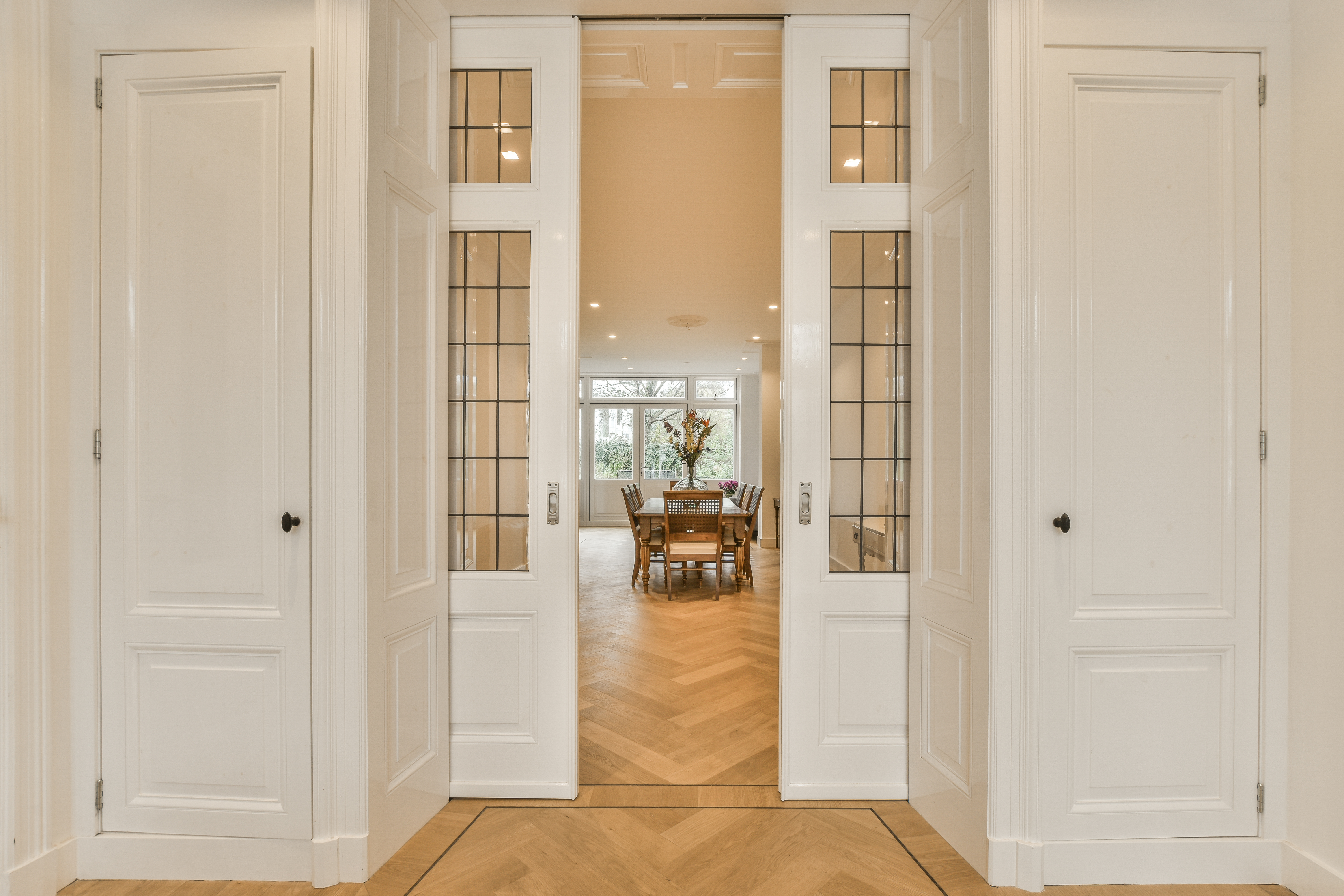 Two quality pocket doors opening to showcase a modern dining room. 