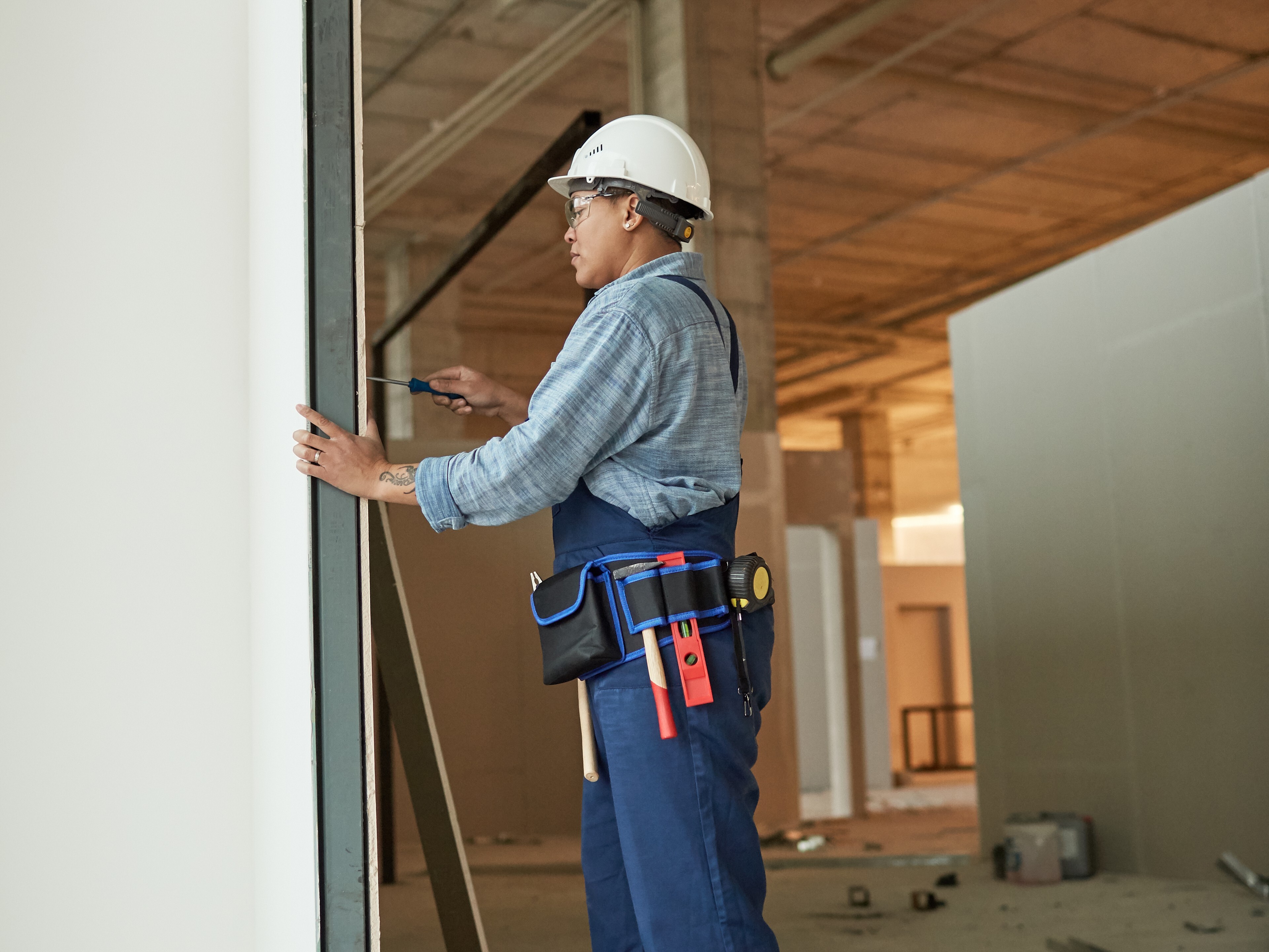 A builder installing a pocket door in a house under construction.  