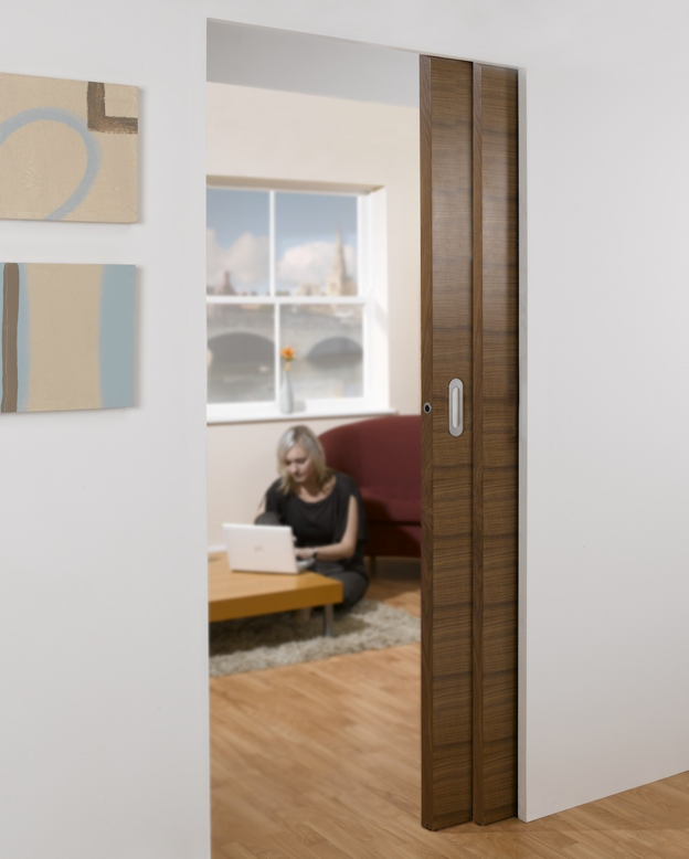 A modern interior showing a completed door replacement with a space-saving pocket door installed within the wall. 